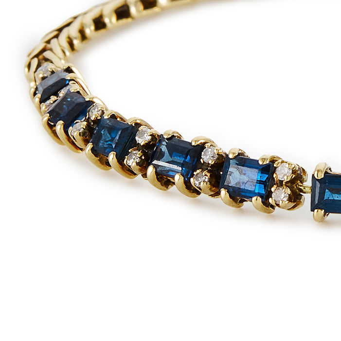 Classic 14ct gold tennis bracelet, set with twelve deep blue rectangular sapphires and twenty-four small diamonds.