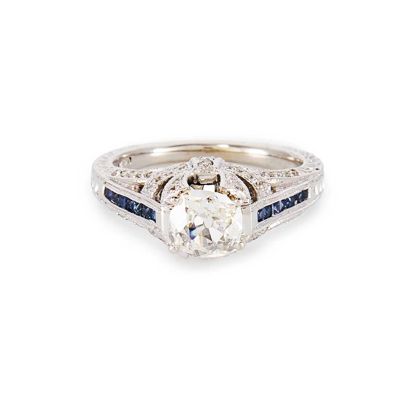 Magnificent 14ct white gold ring, set with a 0.70ct Old-European-Cut diamond, as well as seven princess-cut sapphires on each shoulder. The ring also features a diamond encrusted gallery. A valuation from The Gem Lab is included.