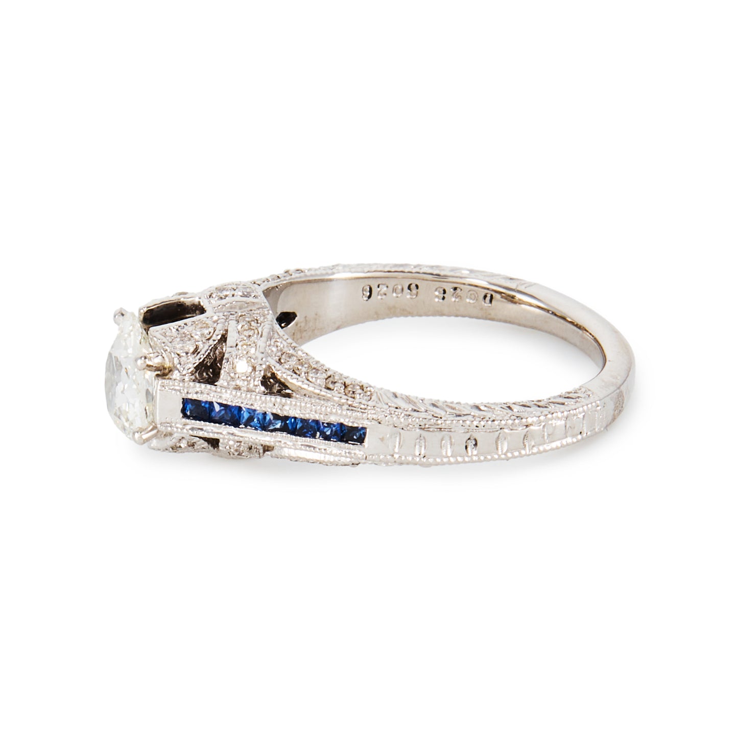 Magnificent 14ct white gold ring, set with a 0.70ct Old-European-Cut diamond, as well as seven princess-cut sapphires on each shoulder. The ring also features a diamond encrusted gallery. A valuation from The Gem Lab is included.