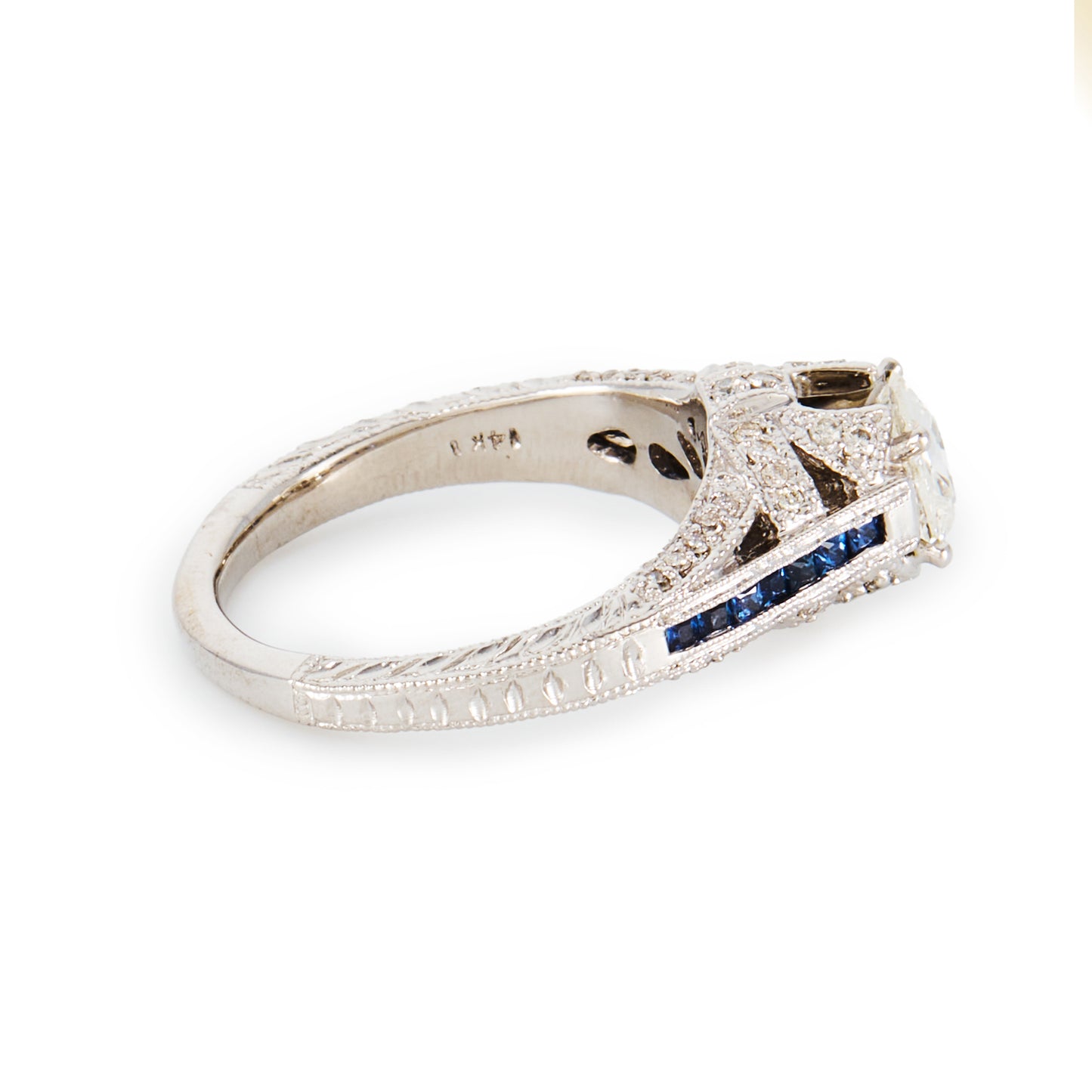 Magnificent 14ct white gold ring, set with a 0.70ct Old-European-Cut diamond, as well as seven princess-cut sapphires on each shoulder. The ring also features a diamond encrusted gallery. A valuation from The Gem Lab is included.