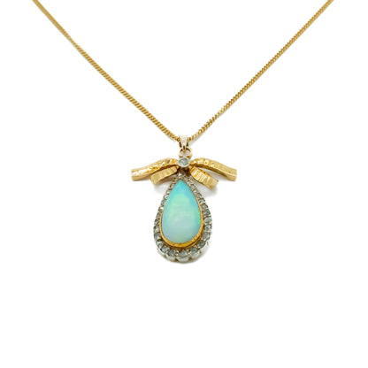 Exquisite 18ct yellow gold pendant set with a luminous opal surrounded by old-cut diamonds on an 18ct gold chain.