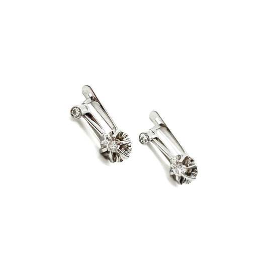 Classic 18ct white gold drop earrings each set with two old-European-cut diamonds (0.04ct and 0.07ct). Circa 1930’s
