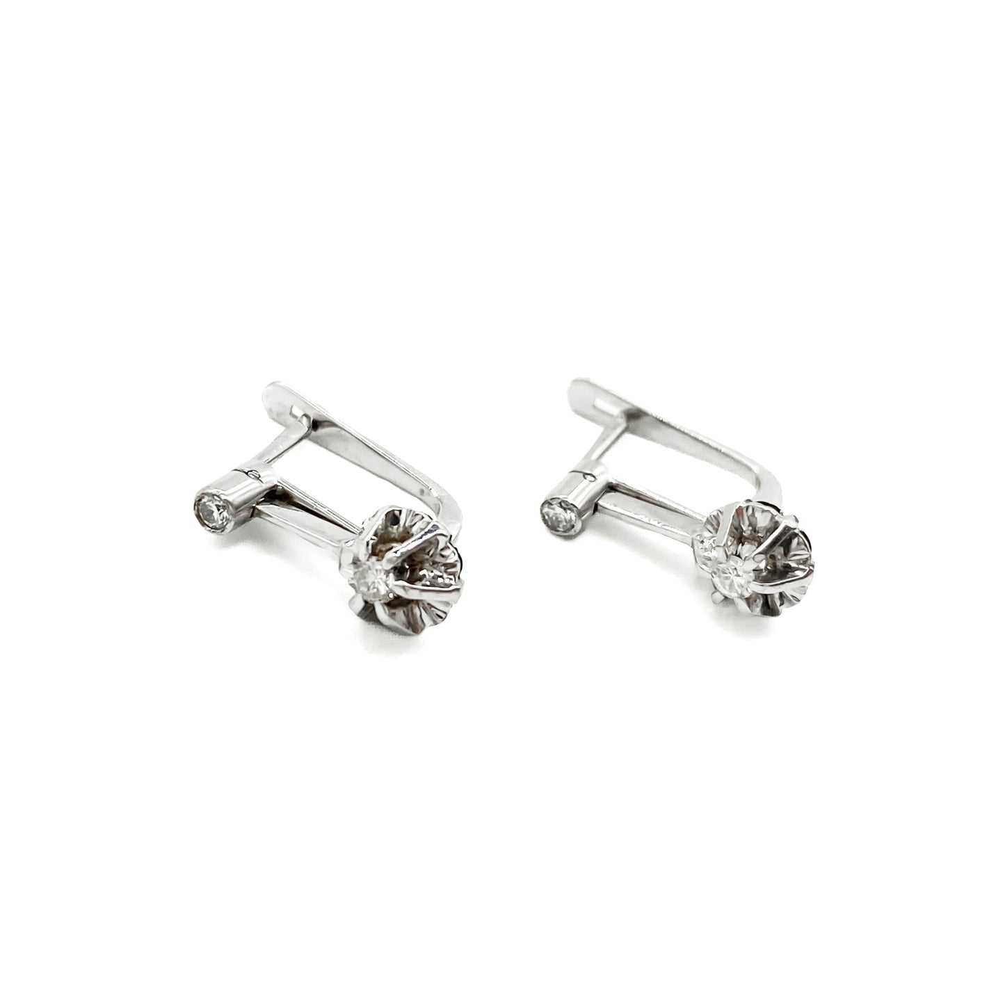 Classic 18ct white gold drop earrings each set with two old-European-cut diamonds (0.04ct and 0.07ct). Circa 1930’s