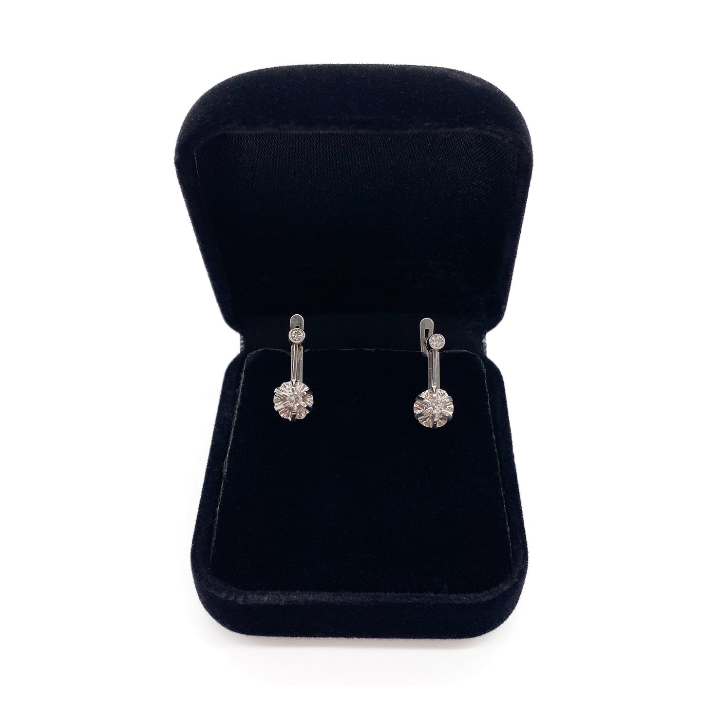 Classic 18ct white gold drop earrings each set with two old-European-cut diamonds (0.04ct and 0.07ct). Circa 1930’s