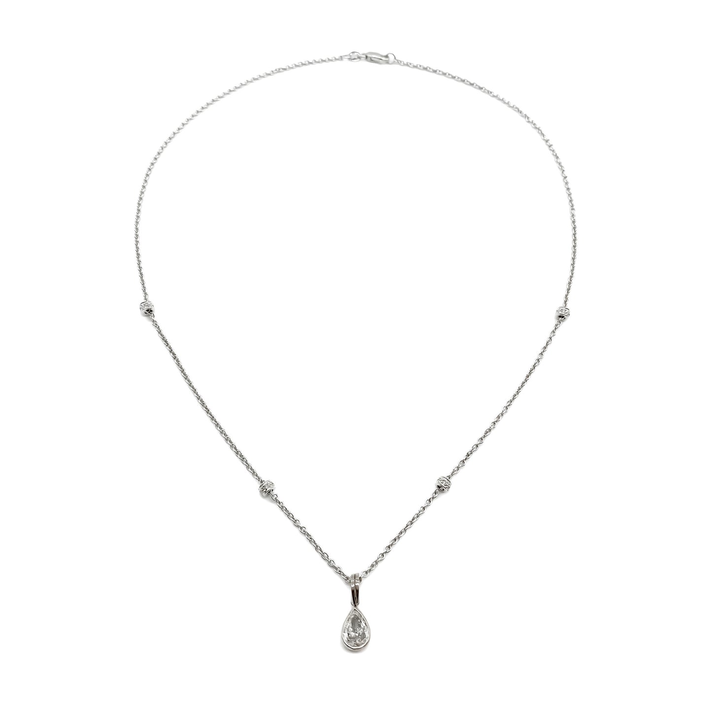 Stylish 18ct white gold necklace set with a 0.85ct pear-shaped centre diamond drop and four beads encrusted with small diamonds.