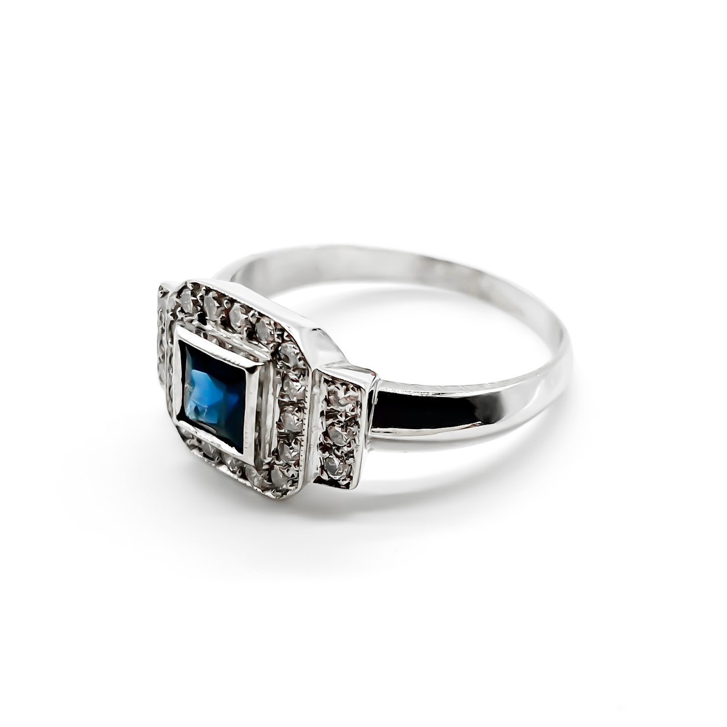 Stunning 18ct white gold ring set with a princess cut sapphire and twenty-two small sparkling diamonds.