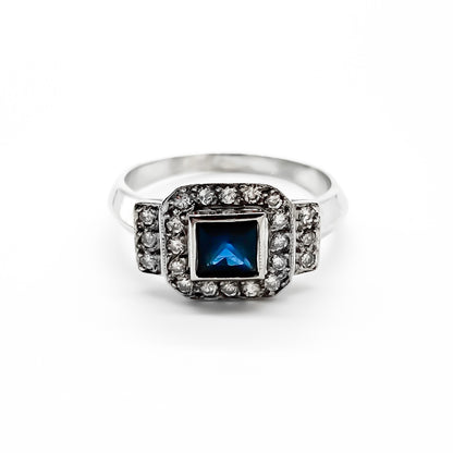 Stunning 18ct white gold ring set with a princess cut sapphire and twenty-two small sparkling diamonds.
