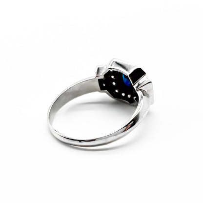 Stunning 18ct white gold ring set with a princess cut sapphire and twenty-two small sparkling diamonds.