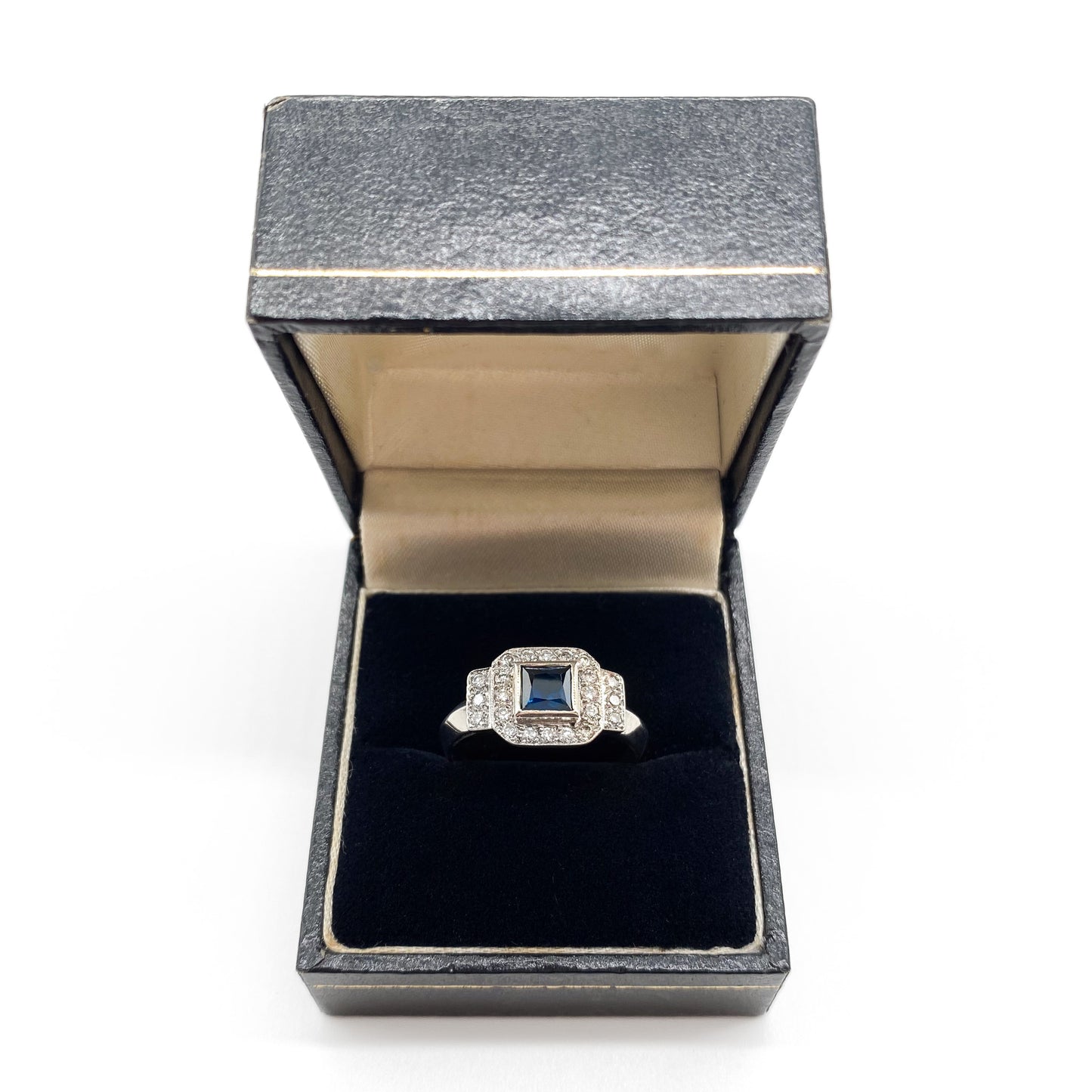 Stunning 18ct white gold ring set with a princess cut sapphire and twenty-two small sparkling diamonds.