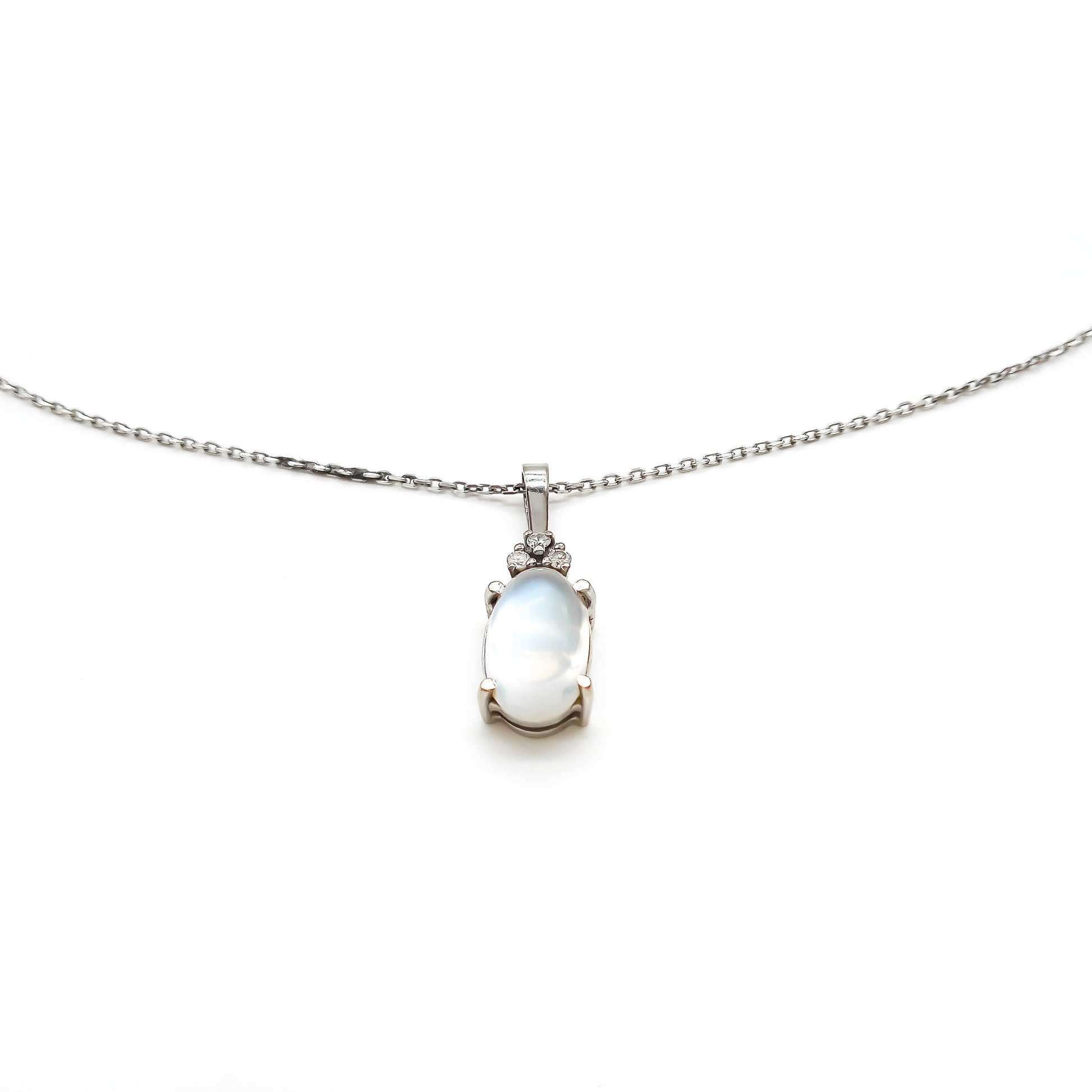 Delicate 18ct white gold pendant set with three small diamonds and a beautiful oval moonstone, on an 18ct white gold chain.