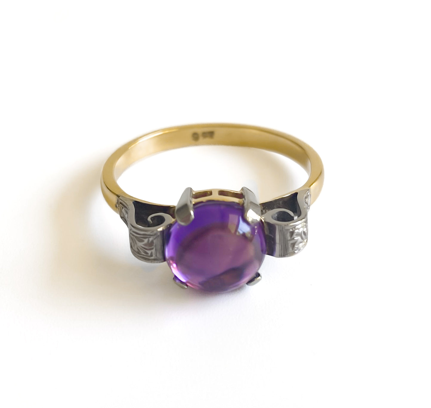 Lovely 9ct yellow gold Art Deco ring set with a round cabochon amethyst. Beautifully engraved 9ct white gold shoulders. Circa 1920’s