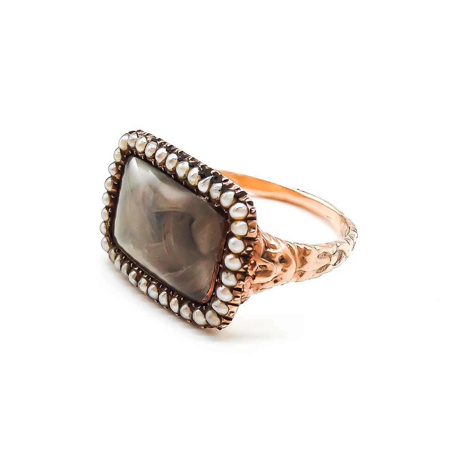 Beautifully crafted Georgian mourning ring in a 9ct rose gold setting with plaited hair under domed glass, adorned with tiny seed pearls. Later shank.