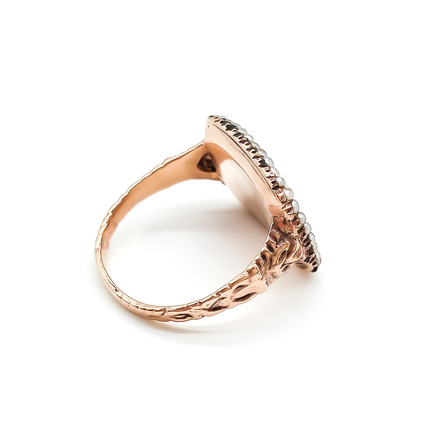 Beautifully crafted Georgian mourning ring in a 9ct rose gold setting with plaited hair under domed glass, adorned with tiny seed pearls. Later shank.