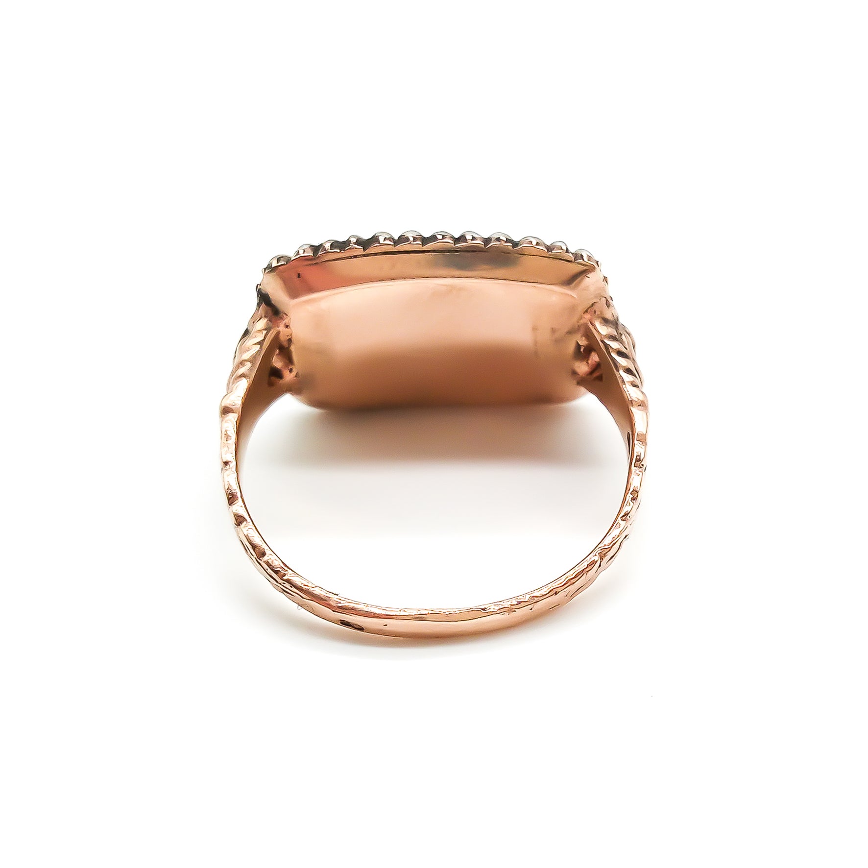 Beautifully crafted Georgian mourning ring in a 9ct rose gold setting with plaited hair under domed glass, adorned with tiny seed pearls. Later shank.