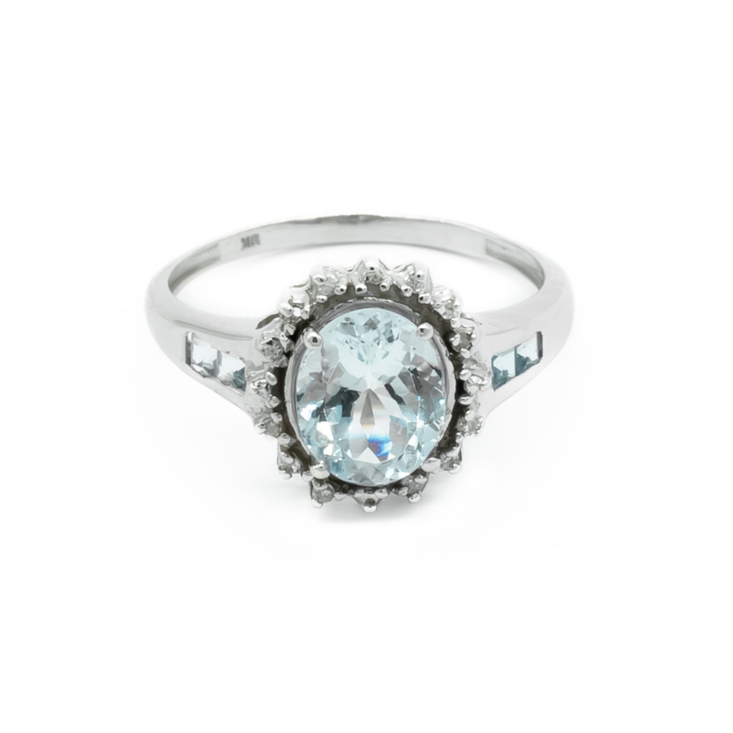 Classic 9ct white gold ring set with a beautifully faceted, light blue aquamarine surrounded by twelve tiny diamonds and two princess cut aquamarines on each shoulder.