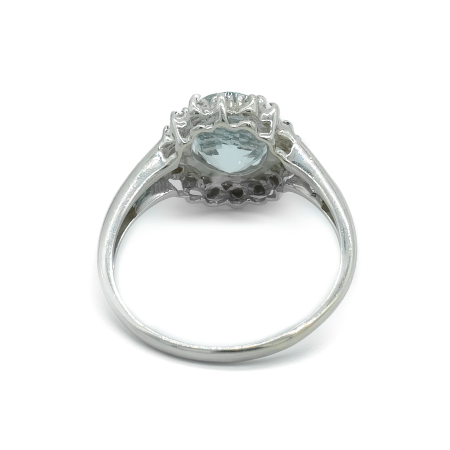 Classic 9ct white gold ring set with a beautifully faceted, light blue aquamarine surrounded by twelve tiny diamonds and two princess cut aquamarines on each shoulder.