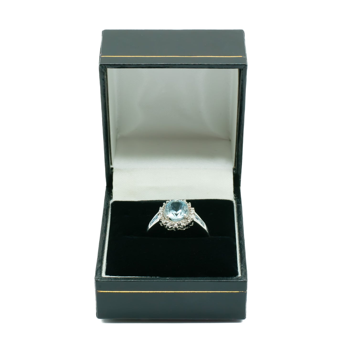 Classic 9ct white gold ring set with a beautifully faceted, light blue aquamarine surrounded by twelve tiny diamonds and two princess cut aquamarines on each shoulder.