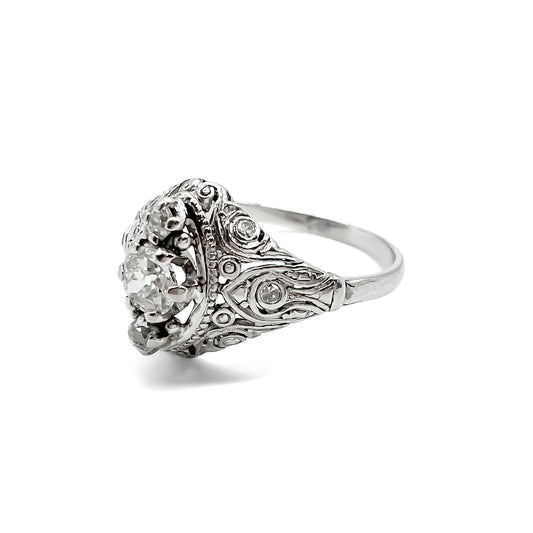 Pretty Art Deco platinum ring set with three centre diamonds and three small diamonds on each shoulder, complemented with beautiful filigree detail.