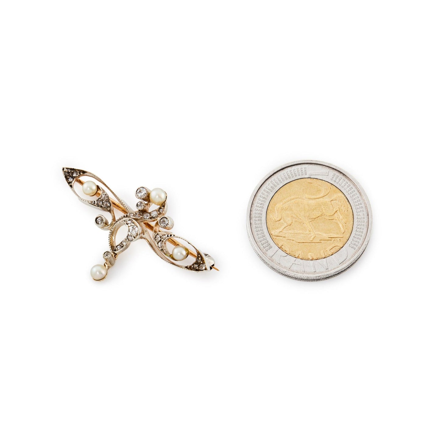 Delicate rose gold and silver Art Nouveau brooch set with old cut diamonds and four small pearls in a free flowing design, with a small diamond and pearl drop.