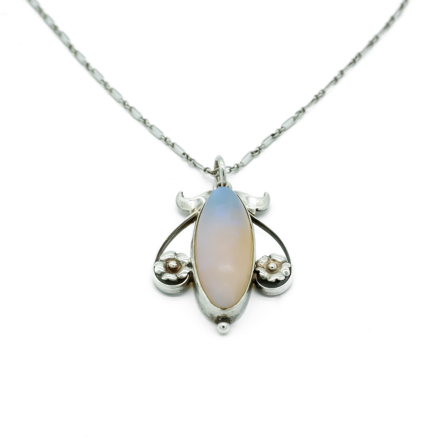 Exquisite silver Art Nouveau pendant set with a luminescent oval moonstone on a delicate fancy link chain.