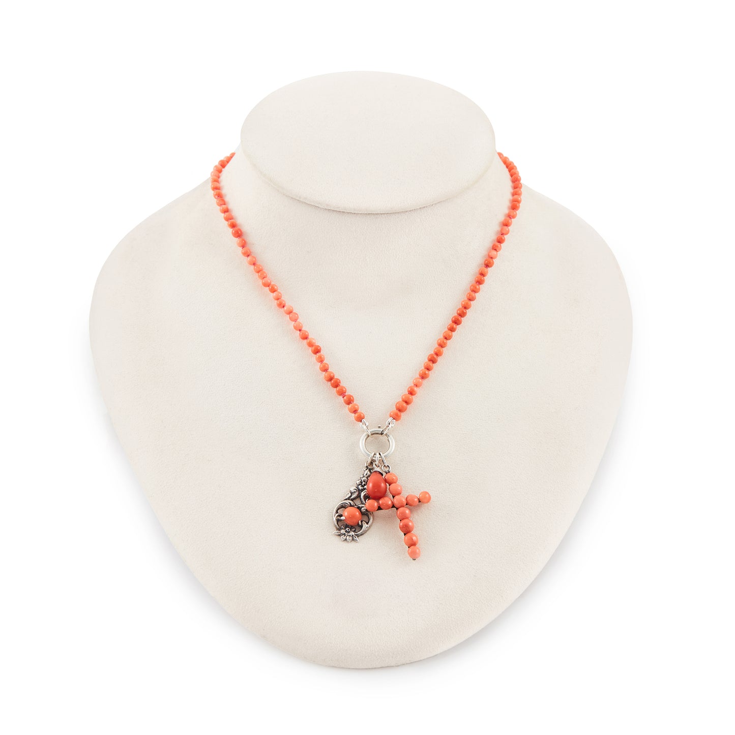 Quaint beaded natural coral necklace with three vintage silver and coral charms attached to a silver bolt ring.