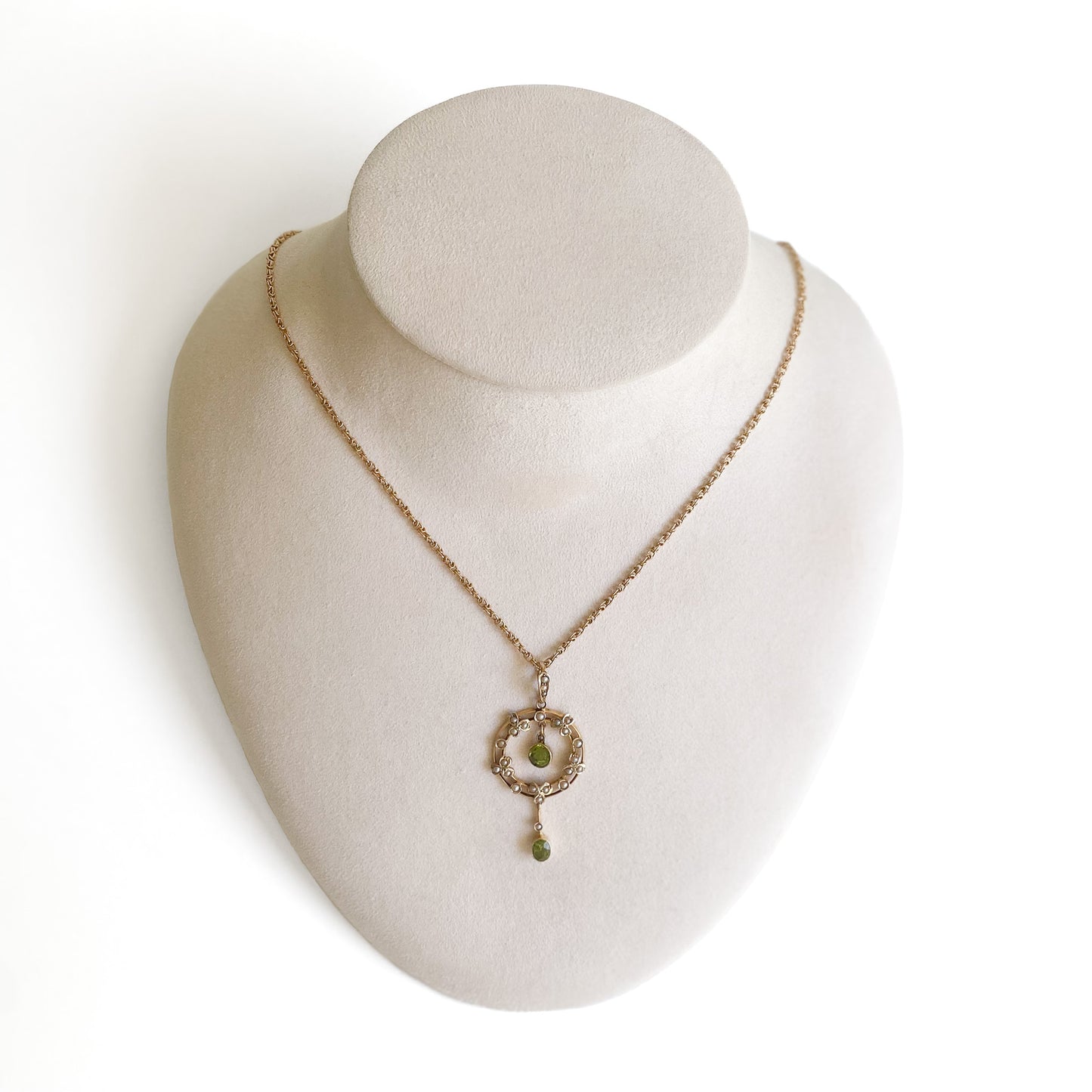 Stunning Edwardian 9ct gold dangling pendant set with two beautifully faceted green peridots and twenty-four tiny seed pearls. On an original 9ct gold fancy link chain.