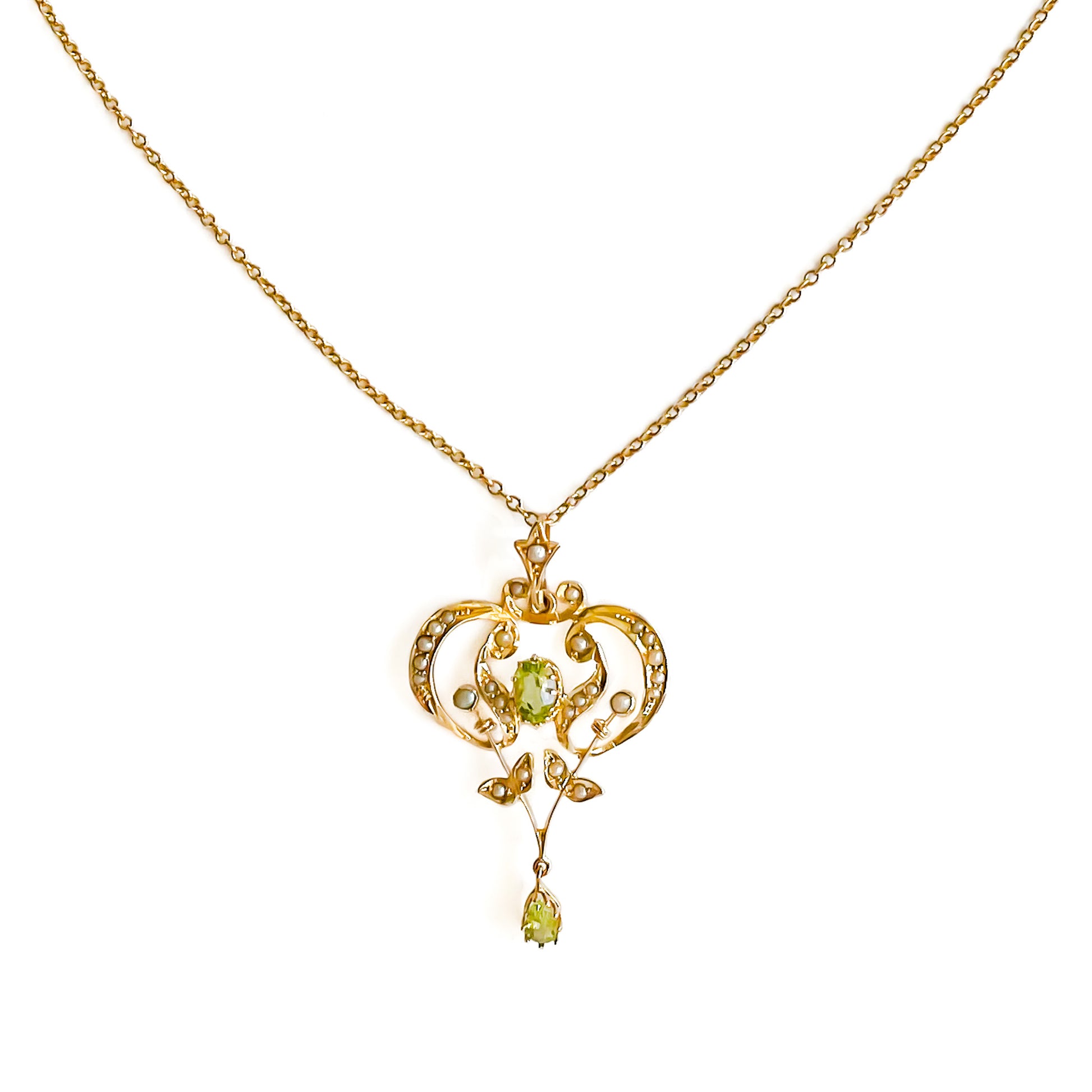 Exquisite Edwardian 9ct yellow gold pendant set with two faceted peridots and twenty-seven seed pearls.