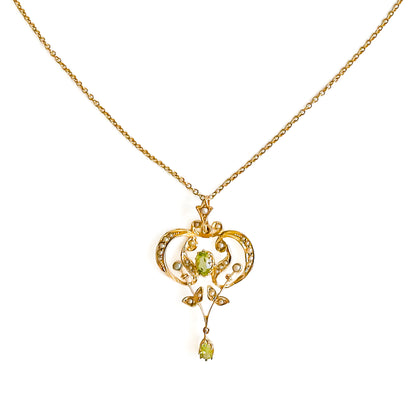 Exquisite Edwardian 9ct yellow gold pendant set with two faceted peridots and twenty-seven seed pearls.