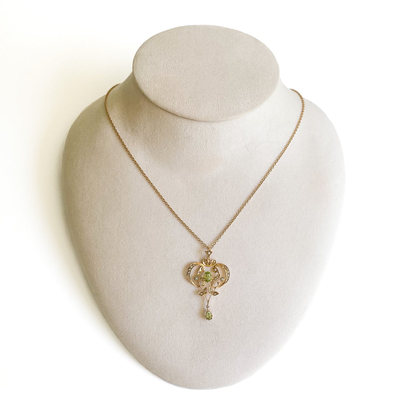 Exquisite Edwardian 9ct yellow gold pendant set with two faceted peridots and twenty-seven seed pearls.