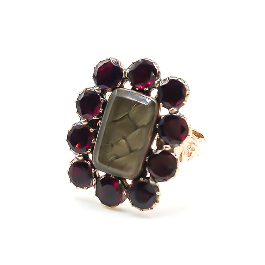 Stunning Georgian mourning ring in a 15ct yellow gold setting with plaited hair under bevelled glass, surrounded by ten beautiful deep red flat cut garnets. Later shank with lovely engraving.
