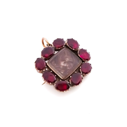 Charming Georgian 9ct rose gold mourning brooch with plaited hair under bevelled glass surrounded by nine Bohemian garnets. 