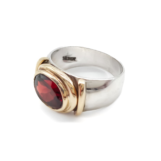 Classic gold and silver ring set with a beautifully faceted deep red oval garnet.