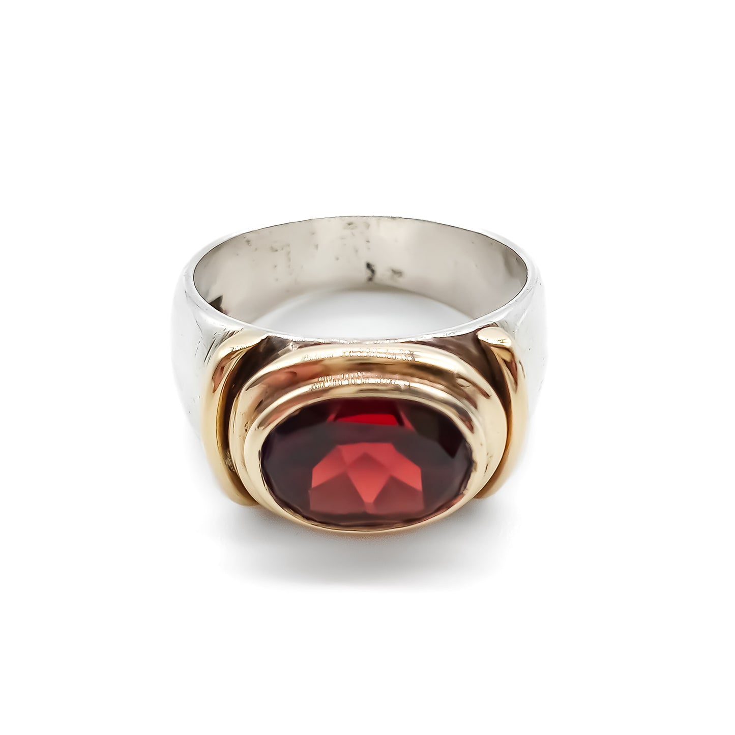 Classic gold and silver ring set with a beautifully faceted deep red oval garnet.