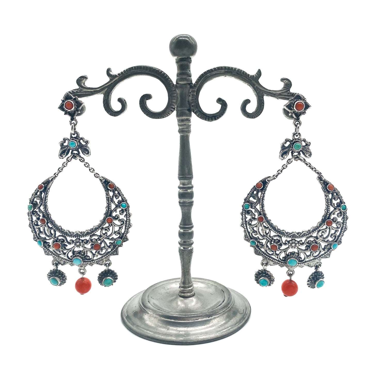 Large, ornate silver drop earrings set with coral and turquoise. Zoltan White and Co.