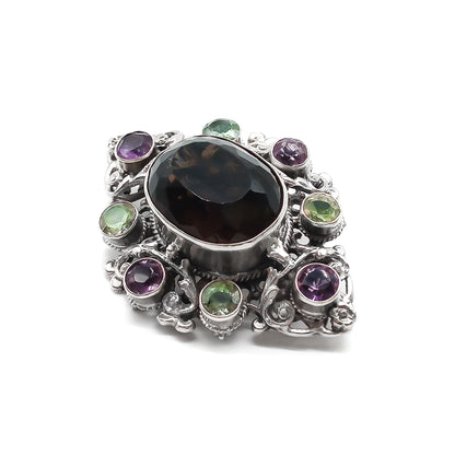 Stunning Arts and Crafts Zoltan White and Co. silver brooch set with a large oval smoky quartz and eight green and purple amethysts. Circa 1920’s