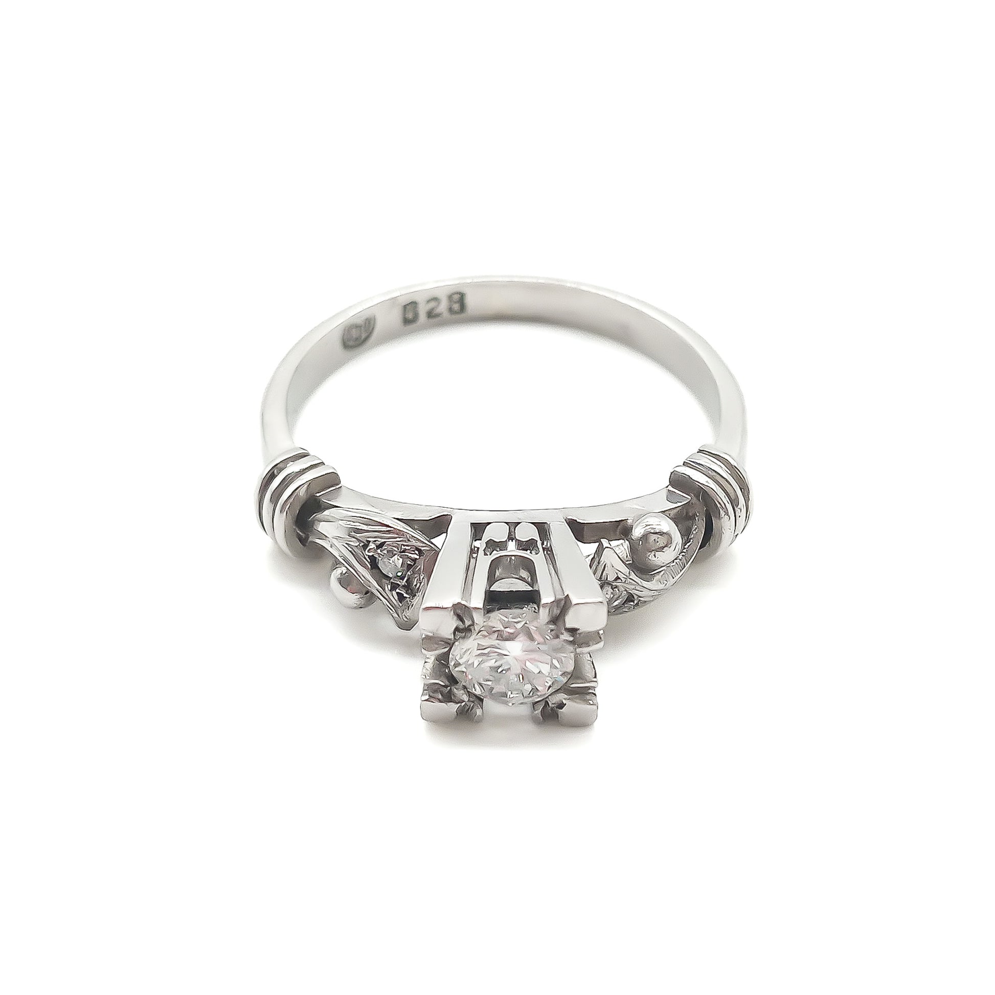 Classic platinum ring with intricate detail, set with an old-cut solitaire diamond and a small diamond on each shoulder. Argentina
