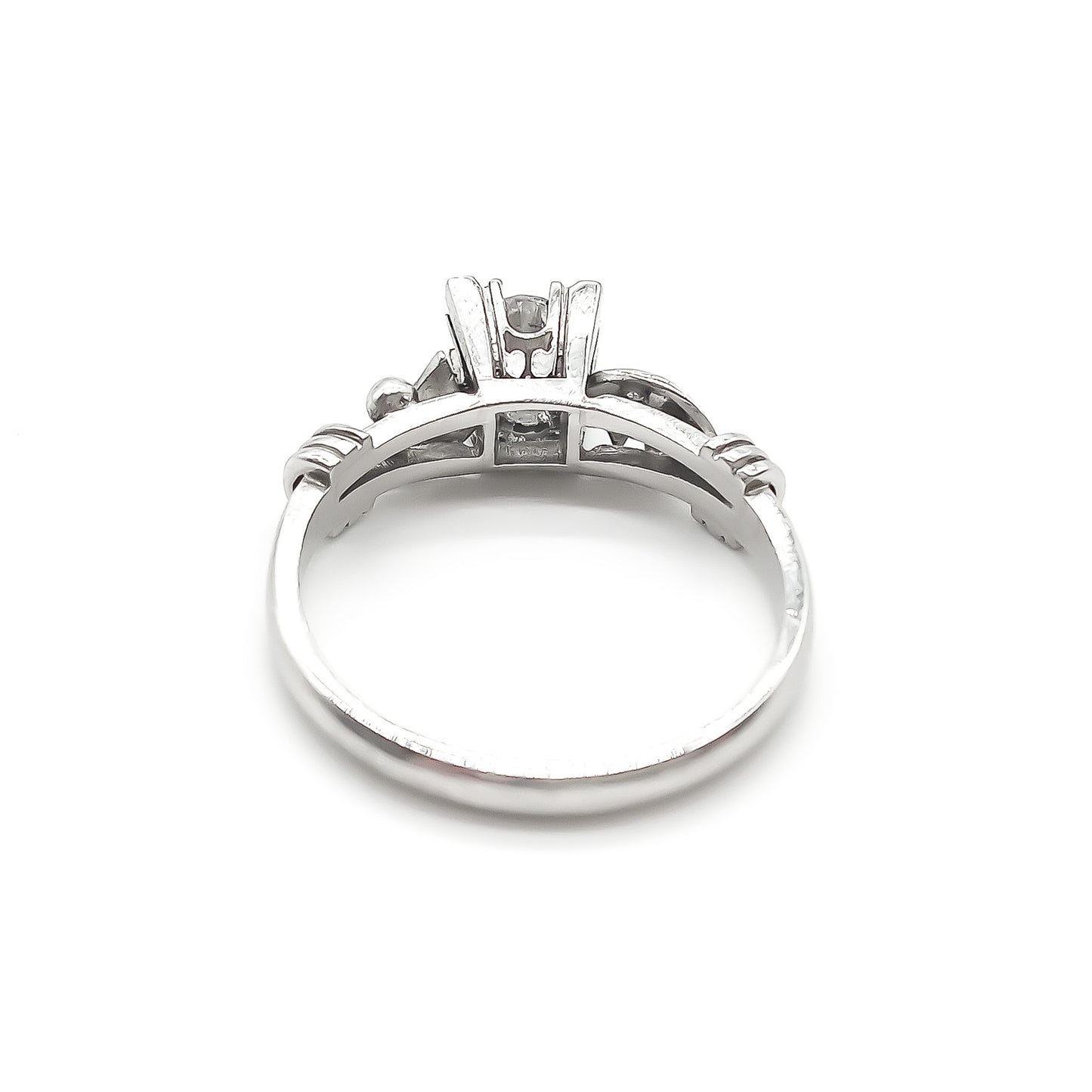 Classic platinum ring with intricate detail, set with an old-cut solitaire diamond and a small diamond on each shoulder. Argentina