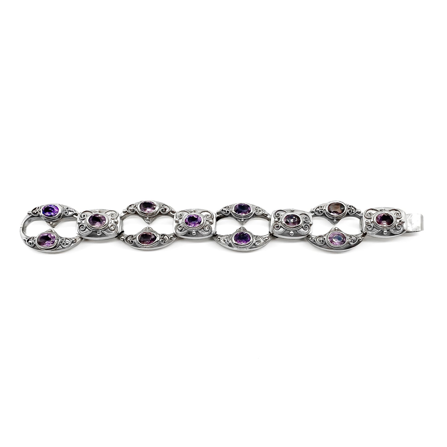 Ornate silver bracelet set with twelve oval faceted amethysts (800 silver). Circa 1930’s