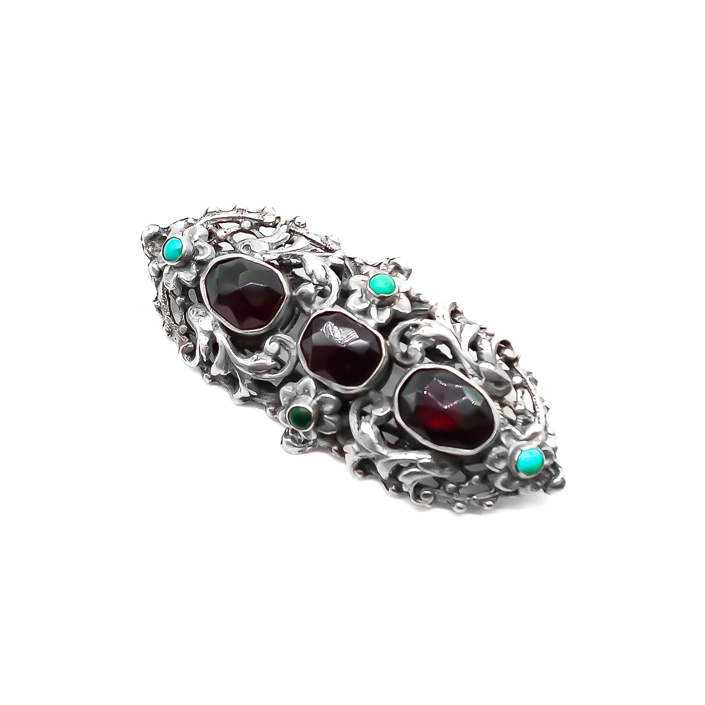 Intricate sterling silver Arts and Crafts brooch set with three large faceted Bohemian garnets and four small turquoise stones. Zoltan White & Company.