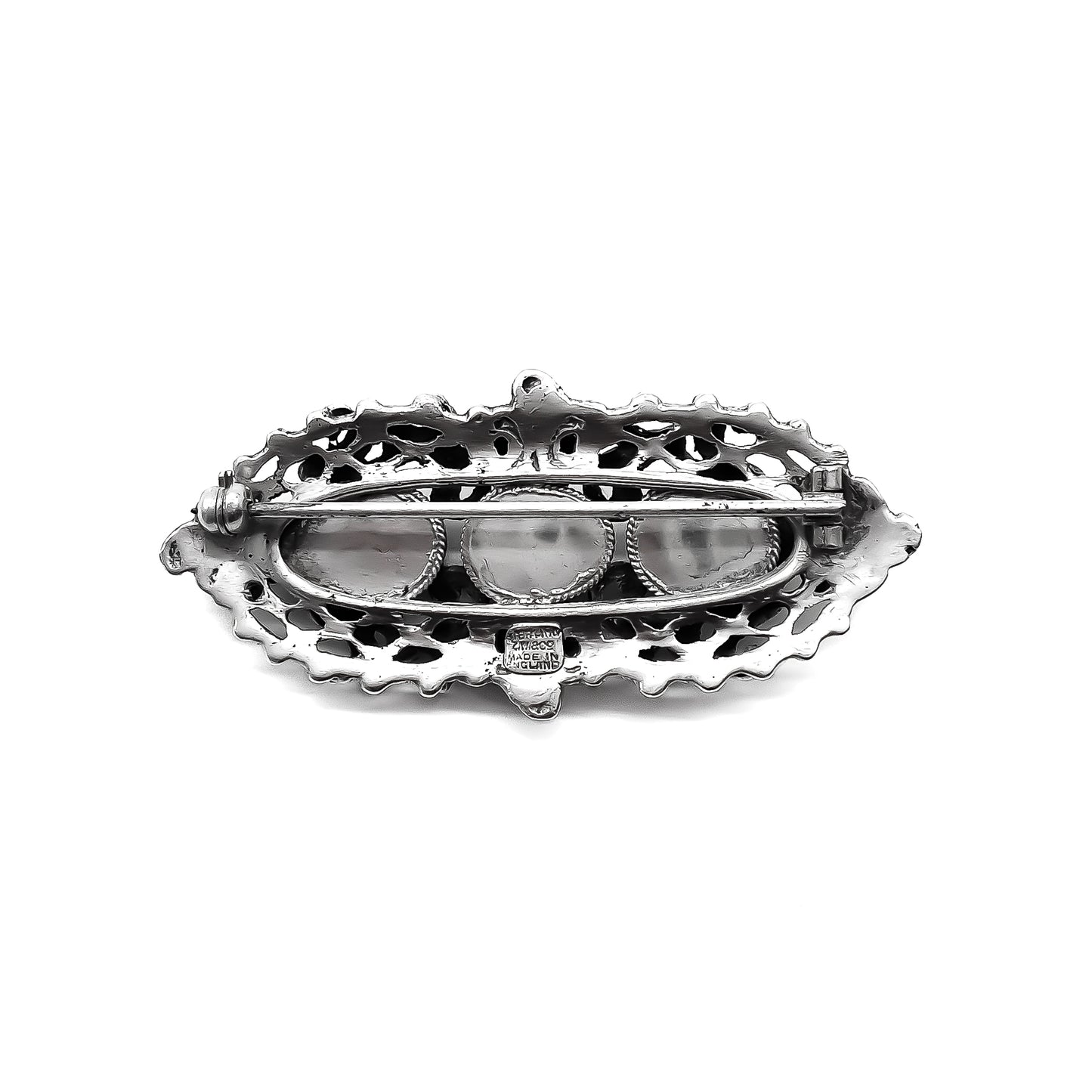 Intricate sterling silver Arts and Crafts brooch set with three large faceted Bohemian garnets and four small turquoise stones. Zoltan White & Company.