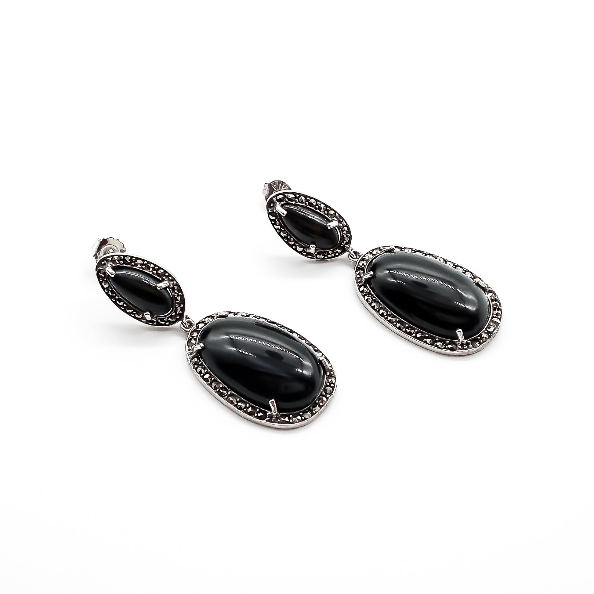Stylish sterling silver drop earrings, each set with two black tiger’s eye cabochon stones, surrounded by marcasites. Circa 1950’s