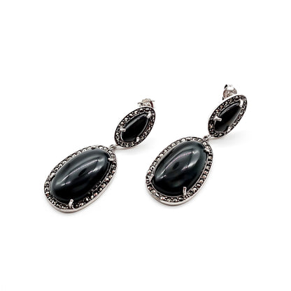 Stylish sterling silver drop earrings, each set with two black tiger’s eye cabochon stones, surrounded by marcasites. Circa 1950’s