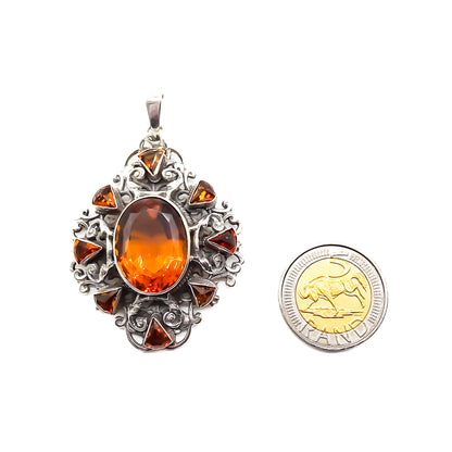 Very ornate sterling silver Arts and Crafts pendant set with a large, beautifully faceted citrine, surrounded by eight small triangular citrines. Circa 1920’s