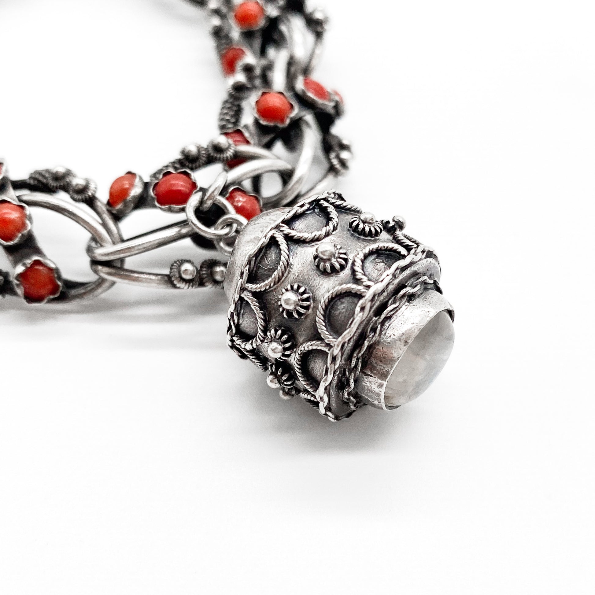 Stunning silver filigree bracelet set with thirty-six natural coral cabochons and three large charms set with coral, moonstone and chrysoprase. Italy