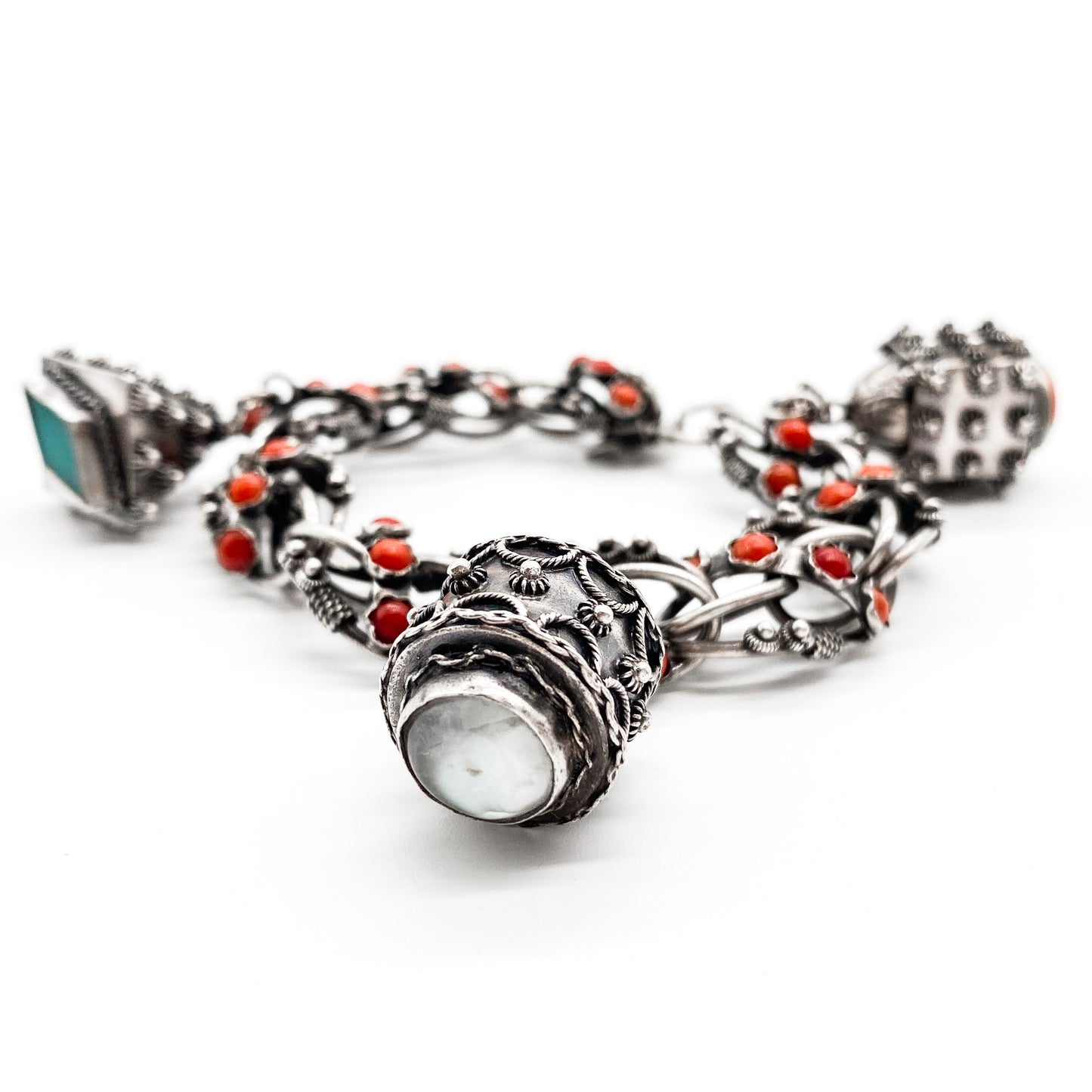 Stunning silver filigree bracelet set with thirty-six natural coral cabochons and three large charms set with coral, moonstone and chrysoprase. Italy