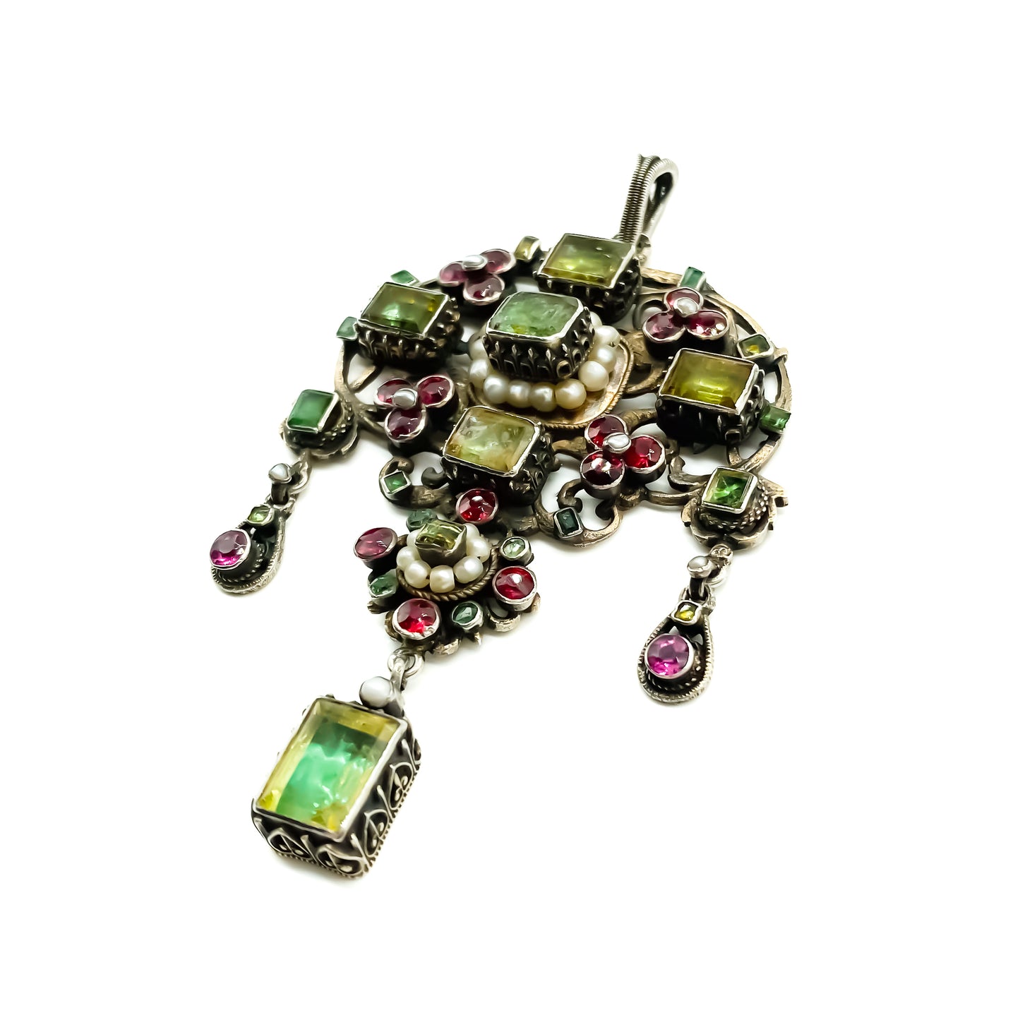 Very ornate silver gilt Austro-Hungarian Festoon pendant set with garnets, seed pearls, emeralds and other green stones. Pendant has beautiful engraving and floral detail. Circa 1890