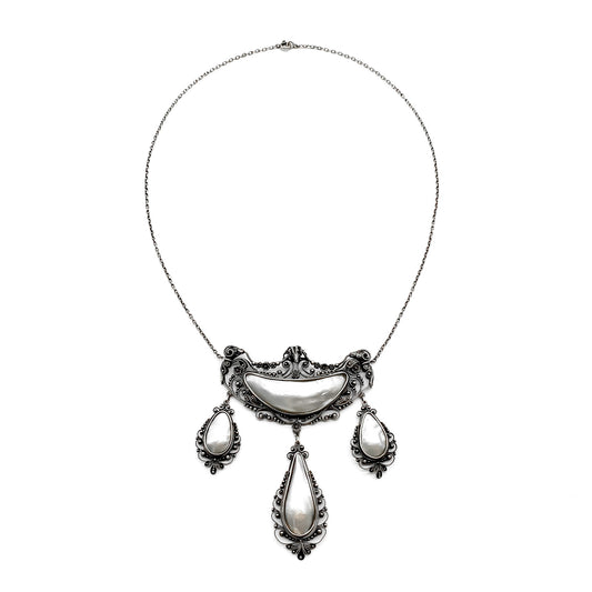 Magnificent oxidised silver festoon necklace with ram’s head detail. Set with four lustrous mother of pearl pieces. Circa 1910