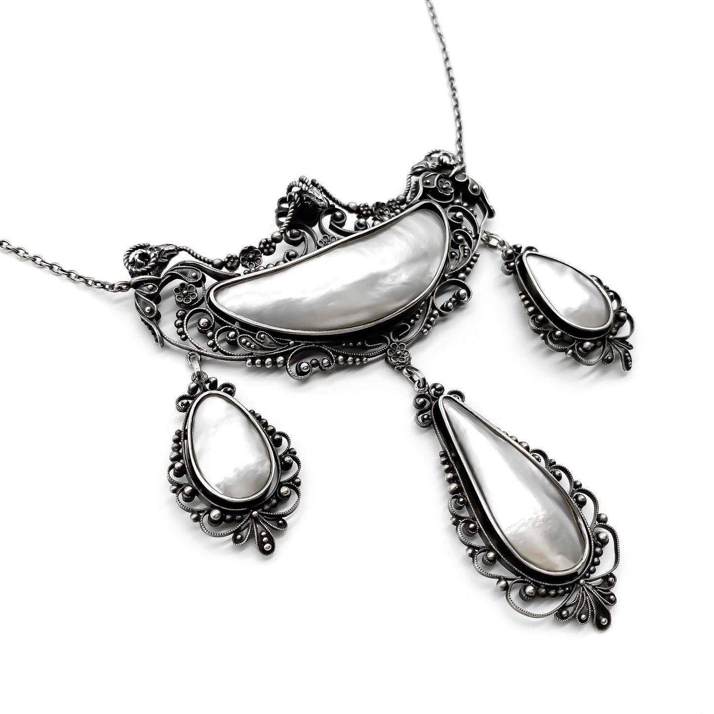 Magnificent oxidised silver festoon necklace with ram’s head detail. Set with four lustrous mother of pearl pieces. Circa 1910