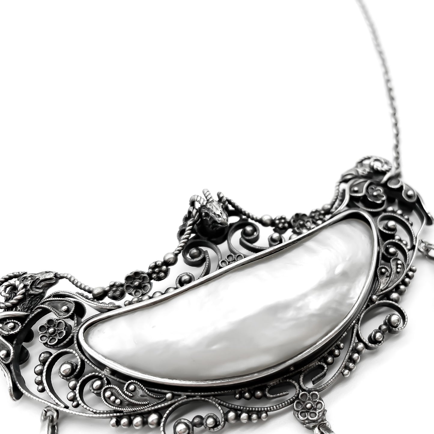 Magnificent oxidised silver festoon necklace with ram’s head detail. Set with four lustrous mother of pearl pieces. Circa 1910