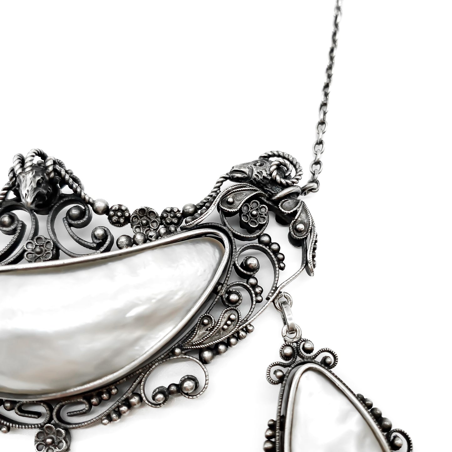 Magnificent oxidised silver festoon necklace with ram’s head detail. Set with four lustrous mother of pearl pieces. Circa 1910
